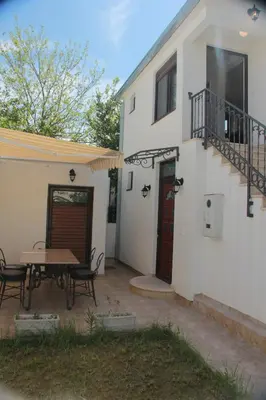 a patio with a wooden table next to a house at Apartments Aneta in Ulcinj
