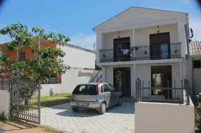 a car parked in front of a white house at Apartments Aneta in Ulcinj