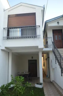 a white house with a balcony and a table at Apartments Aneta in Ulcinj