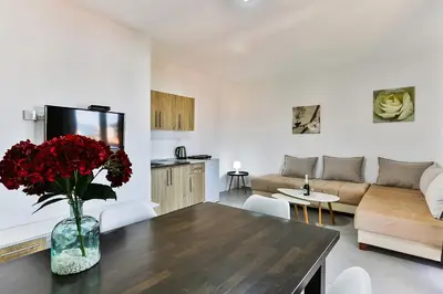 a living room with a vase of red flowers on a table at Apartmani BLUE MOON in Dobra Voda