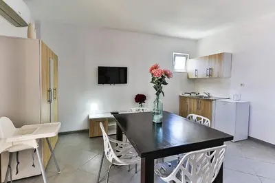 a dining room with a table with a vase of flowers at Apartmani BLUE MOON in Dobra Voda