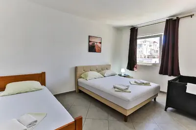 a bedroom with two beds and a window at Apartmani BLUE MOON in Dobra Voda