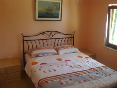 a bedroom with a bed with flowers on it at Holiday House Villa Neda in Utjeha