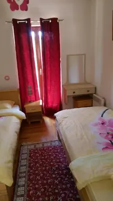 a bedroom with two beds and red curtains at Holiday House Villa Neda in Utjeha