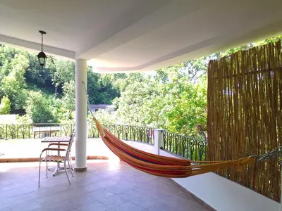 a hammock on a porch of a house at Holiday House Villa Neda in Utjeha