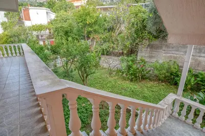 a balcony with a white railing and a yard at Snežna Kraljica in Sutomore