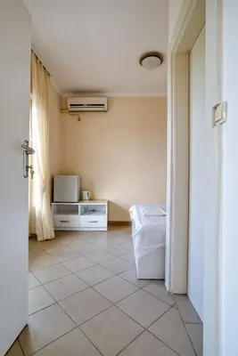 a room with a tiled floor and a room with a microwave at Snežna Kraljica in Sutomore