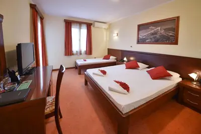 a bedroom with two beds and a desk and a television at Dolce Vita in Budva