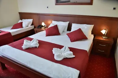 two beds in a hotel room with white and red pillows at Dolce Vita in Budva