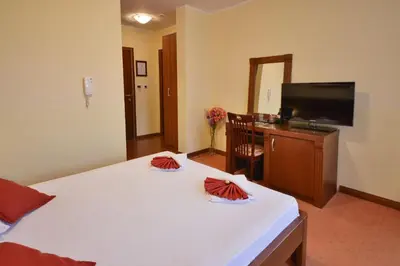 a hotel room with a bed and a flat screen tv at Dolce Vita in Budva