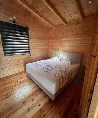 a bedroom with a bed in a wooden cabin at GOLD FISH in Gornji Štoj