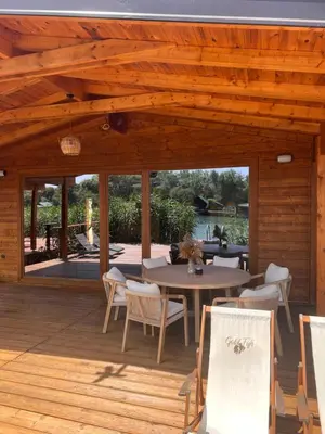 a wooden pavilion with a table and chairs on a deck at GOLD FISH in Gornji Štoj