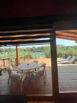 a table and chairs on a deck with a view of the water at GOLD FISH in Gornji Štoj