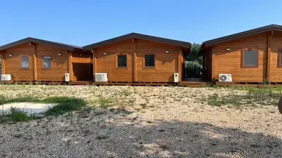 a row of wooden lodges in a field at GOLD FISH in Gornji Štoj