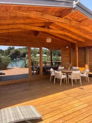 a patio with a table and chairs on a wooden deck at GOLD FISH in Gornji Štoj