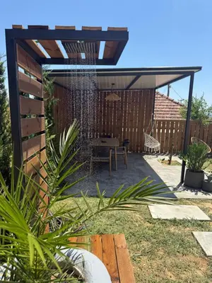 a backyard with a pergola with a table and a swing at The Stonehouse in Ulcinj