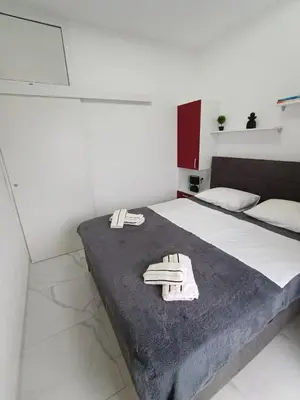 a bedroom with a bed with two towels on it at lux apartmani Porte Nouva in Sutomore