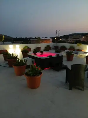 a patio with tables and chairs and potted plants at lux apartmani Porte Nouva in Sutomore