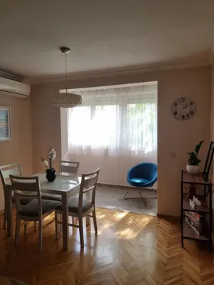 a dining room with a table and chairs and a window at Cozy Central Apartment next to Bus and Train Station in Podgorica