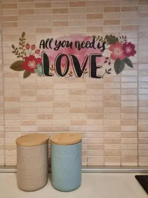 a wall with a sign that says all you need is love at Cozy Central Apartment next to Bus and Train Station in Podgorica