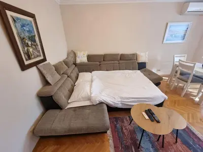 a living room with a couch and a table at Cozy Central Apartment next to Bus and Train Station in Podgorica