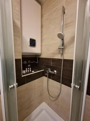 a bathroom with a shower with a sink and a shower at Cozy Central Apartment next to Bus and Train Station in Podgorica