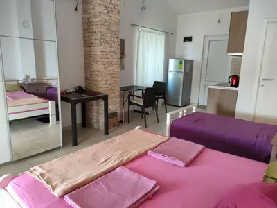 a living room with two beds and a kitchen at 1-Bedroom Apartment in Bigovo