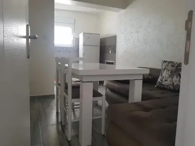 a kitchen with a white table and chairs and a refrigerator at Apartment Danijela in Budva