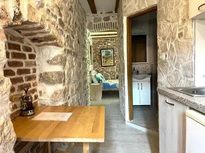 a kitchen with a stone wall and a wooden table at South Gate apartments 262 in Kotor
