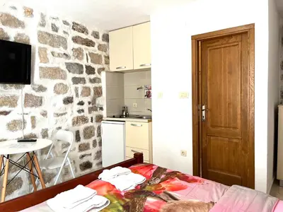 a kitchen and a room with a stone wall at South Gate apartments 262 in Kotor