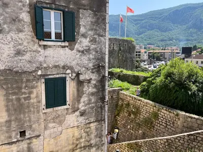 a building with green shutters and a window at South Gate apartments 262 in Kotor