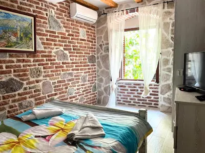 a bedroom with a bed and a brick wall at South Gate apartments 262 in Kotor