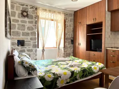 a bedroom with a bed with a floral bedspread at South Gate apartments 262 in Kotor