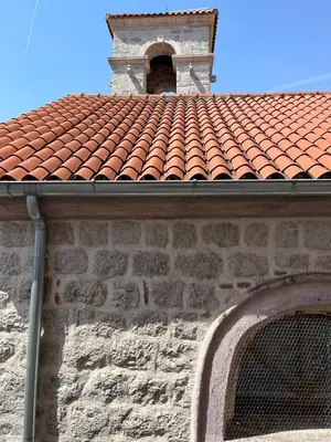 a building with a red tile roof with a bell tower at South Gate apartments 262 in Kotor