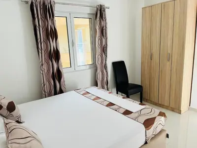 a bedroom with a bed and a chair and a window at Apartments MyDay in Budva