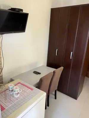 a dining room with a table and a cabinet at Apartments MyDay in Budva