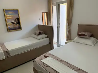 two beds in a hotel room with a window at Apartments MyDay in Budva