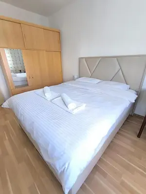 a large white bed with two white pillows on it at Central Station Apartment Podgorica in Podgorica