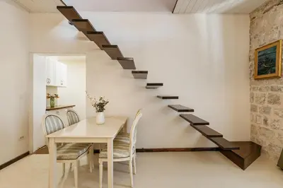 a staircase in a room with a table and chairs at Apartments Leo in Kotor