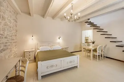 a bedroom with a bed and a spiral staircase at Apartments Leo in Kotor
