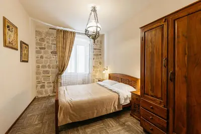 a bedroom with a bed and a dresser and a window at Apartments Leo in Kotor