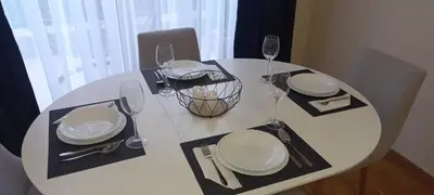 a white table with plates and wine glasses on it at Budva Morska oaza in Budva