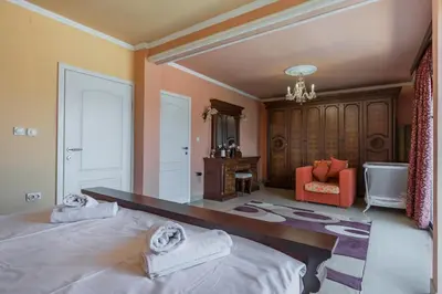 a bedroom with a large bed and a chair at Villa Tivat in Tivat