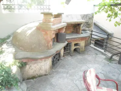 an outdoor pizza oven sitting on a patio at Apartments Pekic in Bar