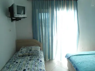a bedroom with a bed and a tv and a window at Apartments Pekic in Bar