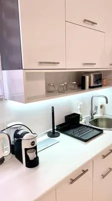 a white kitchen with a sink and a counter top at Apartman DolceRosa in Kotor