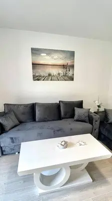 a living room with a couch and a white coffee table at Apartman DolceRosa in Kotor