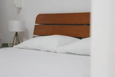 a bed with white sheets and a wooden headboard at deleted account in Kotor