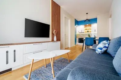 a living room with a blue couch and a tv at Skyline Apartments by In Property in Becici