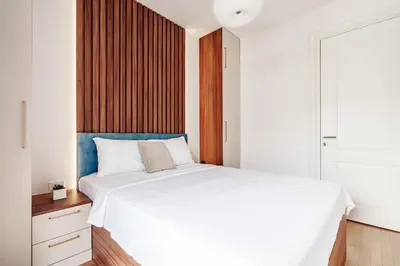 a bedroom with a white bed with a blue headboard at Skyline Apartments by In Property in Becici